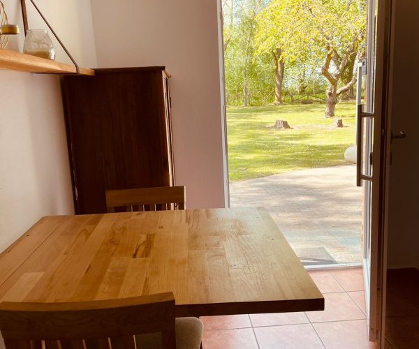 Kleine, funktional eingerichtete Ferienwohnung-Küche im Landhausstil mit hellbraunen Fliesen.